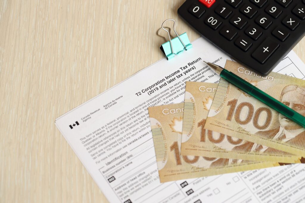 Canadian T2 tax form Corporation income tax return lies on table with canadian money bills